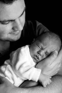 Father holding his baby, sombre tones