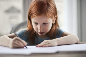 Child concentrating while drawing, illustrating cognitive development linked to maternal sensitivity in preterm children