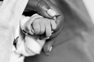 Neonatal end-of-life care with a parent holding a newborn's hand